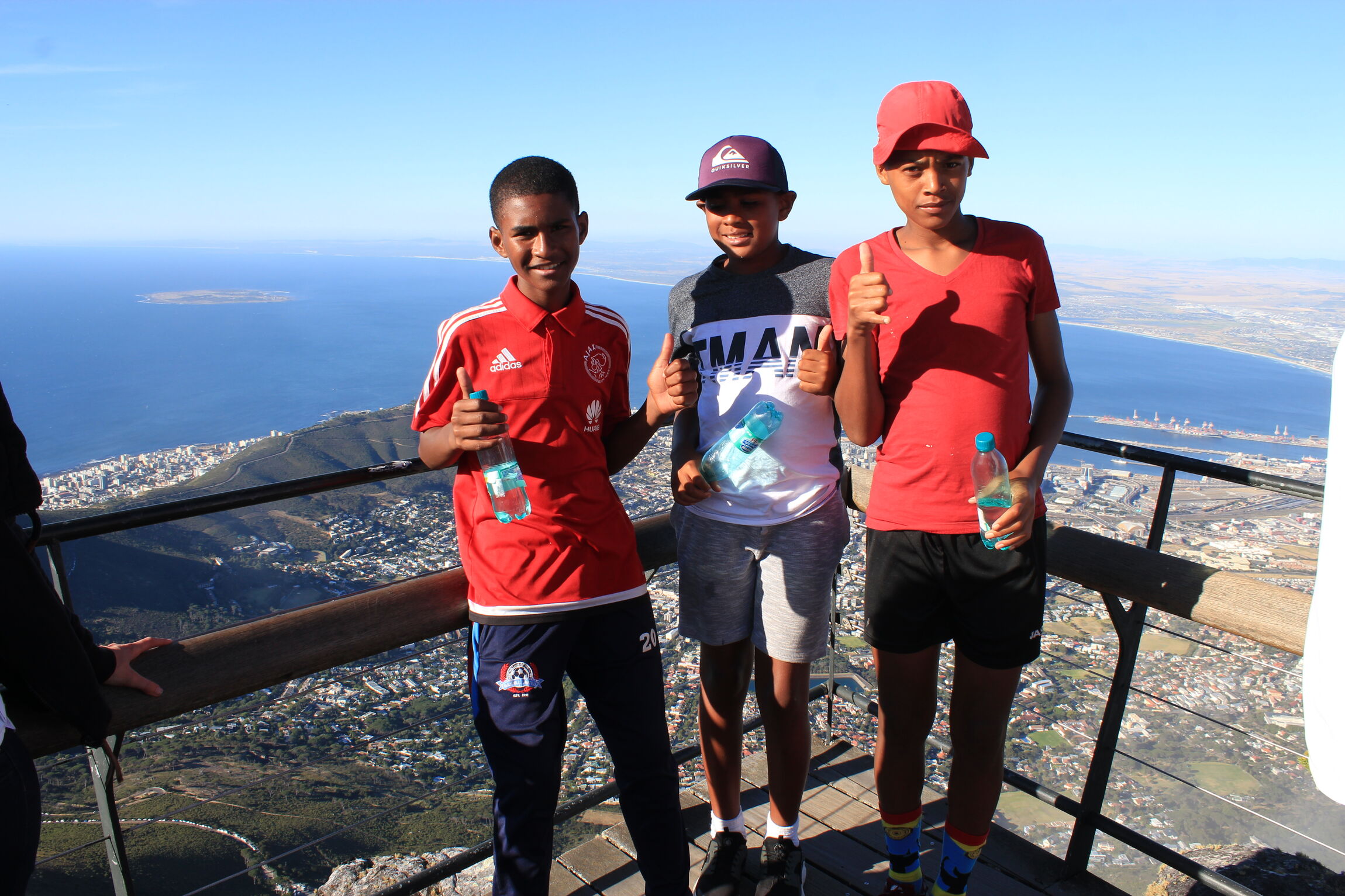 Drei der Fußballkids auf dem Tafelberg, im Hintergrund die Insel Robben Island