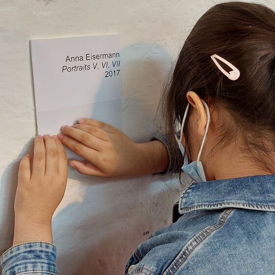 Kunstobjekt Anna Eisermann- ein Mädchen liest die Erklärung in Blindenschrift