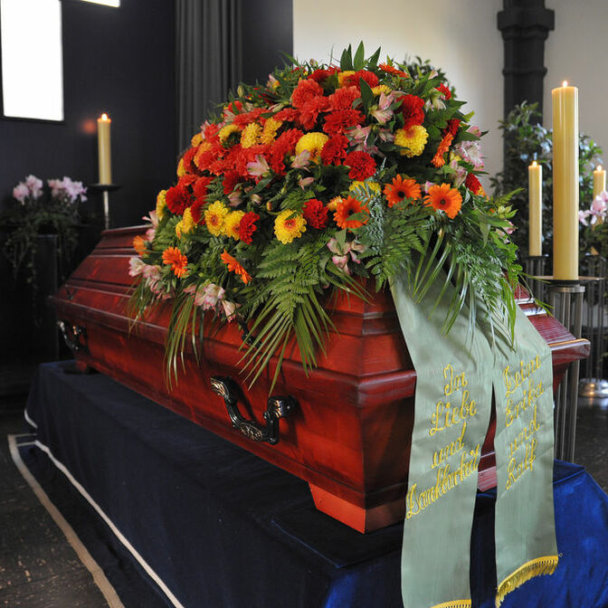 Bestattung & Vorsorge - Sarg mit Blumenschmuck