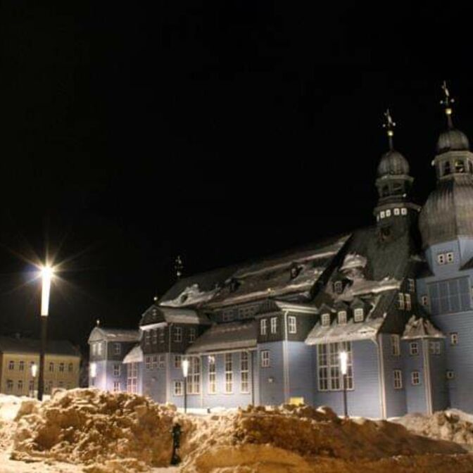 Vor der Clausthaler Marktkirche "Zum Heiligen Geist" türmen sich im Winter Schneeberge.